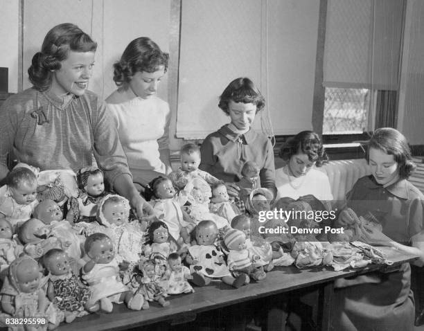 Help Needed--Skinner junior high school girls show the dolls on which the school sewing class worked most of the year and which will be distributed...