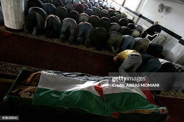 Mourners attend the funeral of a 53-year-old Palestinian woman who died of a heart attack after Israeli soldiers came to her house overnight to...