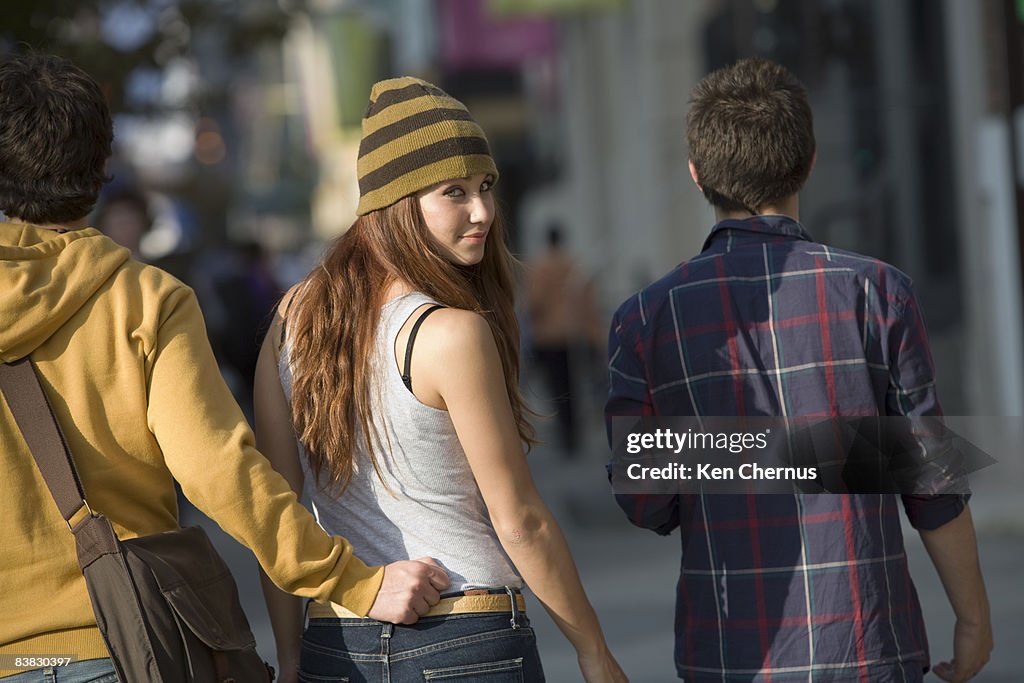 Group of friends walking on urban street scene 