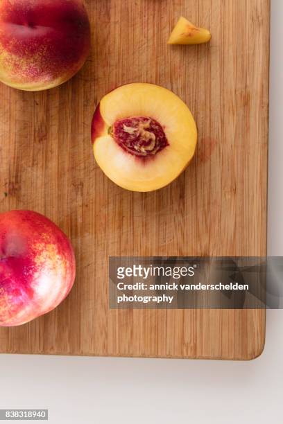 chopped nectarines on a wooden chopping board. - nektarine stock-fotos und bilder