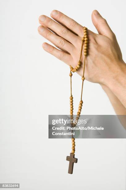 clasped hands holding rosary with crucifix, cropped view - rosary beads stock pictures, royalty-free photos & images