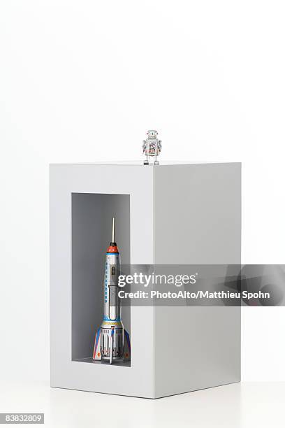 toy robot standing on top of a box with a toy rocket standing up in it - toy box fotografías e imágenes de stock