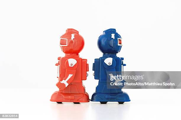 toy robots standing back to back, side view - rivalry stock pictures, royalty-free photos & images