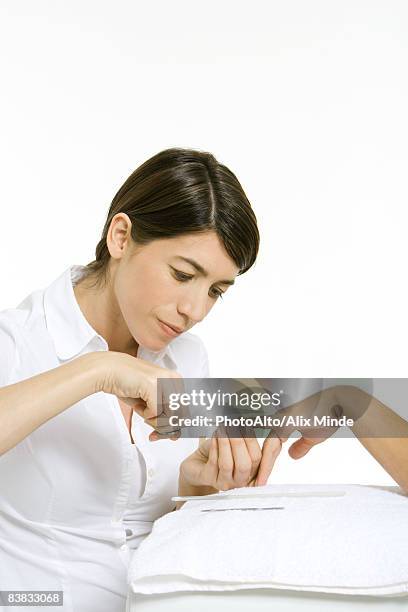beautician trimming a woman's nails with scissors, cropped view of hand - nail scissors - fotografias e filmes do acervo