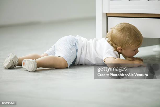 toddler crawling on the ground, side view - chercher sous photos et images de collection