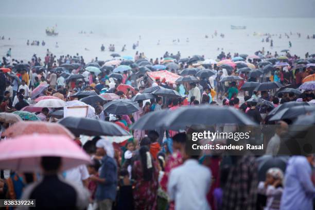 people with umbrella gathered to watch ganesh idol immersion - ganesh chaturthi stock pictures, royalty-free photos & images