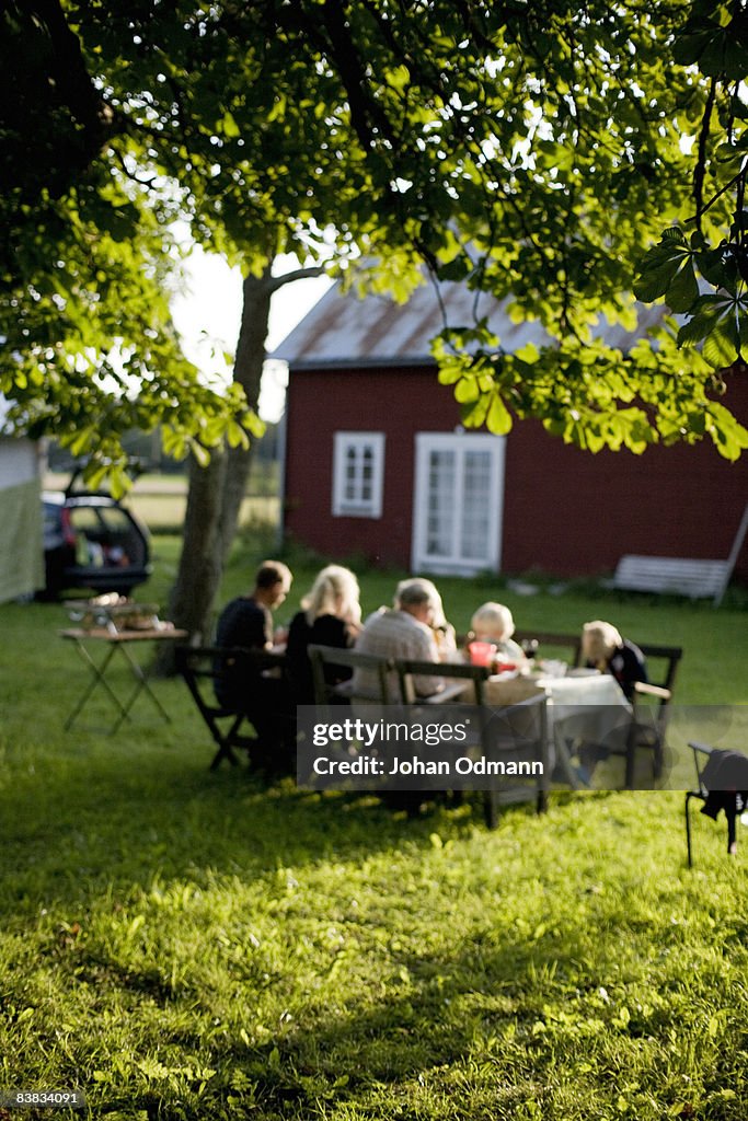 A family having dinner in the garden Gotland Sweden.