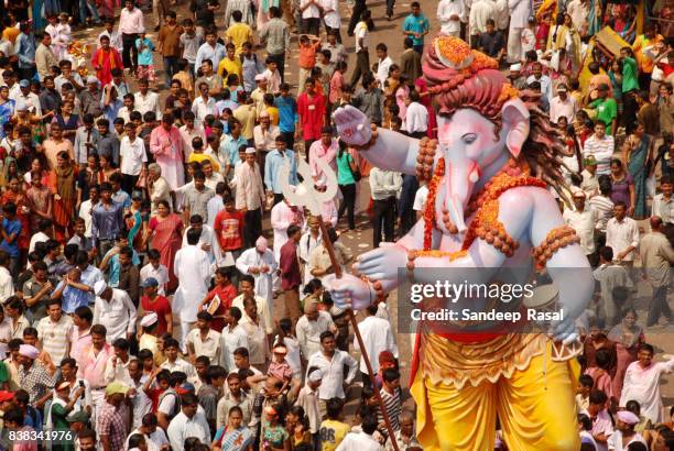 devotees carry ganesh idol for immersion - ganesh chaturthi stock pictures, royalty-free photos & images