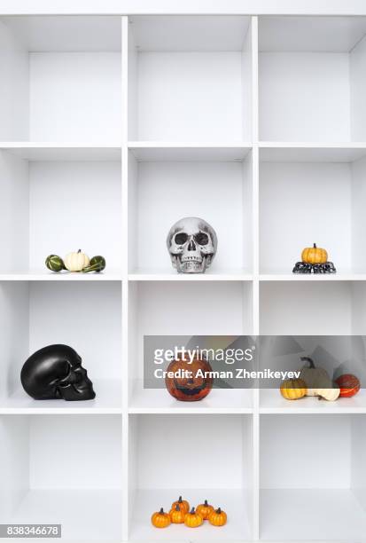 halloween decorations in bookshelf - ugly pumpkins stock-fotos und bilder
