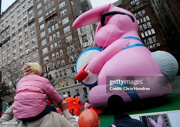 Man with a child watch the Energizer Bunny float get inflated before the annual Macy's Thanksgiving Day Parade November 26, 2008 in the Upper West...