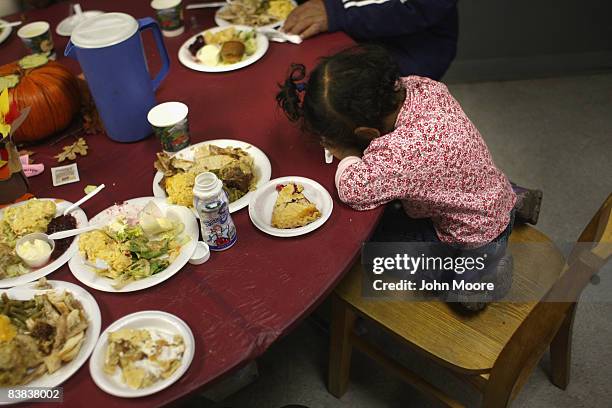 Mary Pyfer, age 3, puts her head down at a Thanksgiving meal November 26, 2008 at a homeless shelter in Denver, Colorado. The Denver Rescue Mission,...
