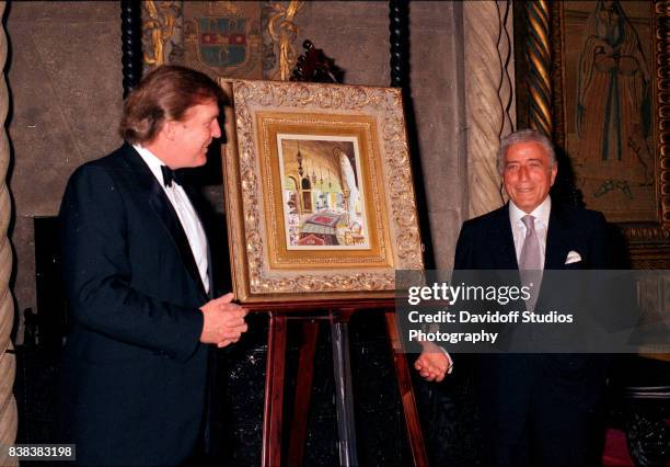 American real estate developer Donald Trump introduces musician Tony Bennett, and the latter's artwork, during a 'roaring 20's' party at the...