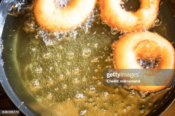 deep frying donuts - freír mediante inmersión total en aceite caliente fotografías e imágenes de stock