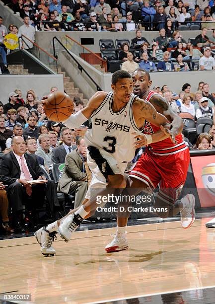 George Hill of the San Antonio Spurs drives against Derrick Rose of the Chicago Bulls on November 26, 2008 at the AT&T Center in San Antonio, Texas....