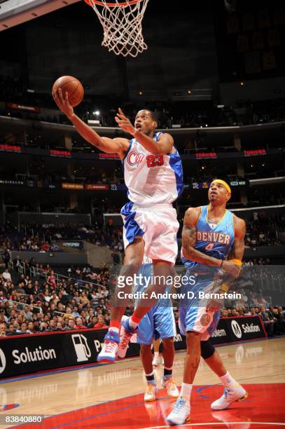 Marcus Camby of the Los Angeles Clippers goes up for a shot while Kenyon Martin of the Denver Nuggets looks on during their game at Staples Center on...