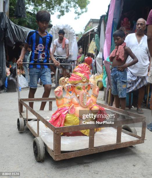 An Indian child carrying the clay idol of elephant headed Hindu god Ganesh from Kumartuli in Kolkata, India on Thursday , 24th August, 2017. The...