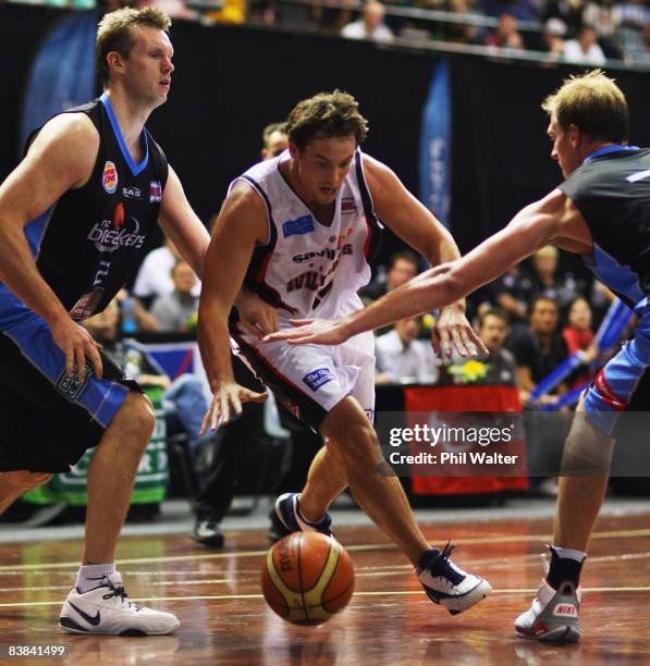 Luke Kendall of the Perth Wildcats takes the ball between Tony Ronaldson and Rick Rickert of the New Zealand Breakers during the round 11 NBL match...