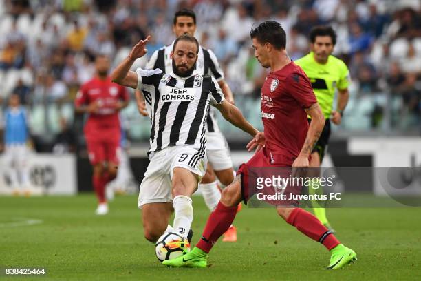 Gonzalo Higuain of Juventus is challenged by Fabio Pisacane of Cagliari during the Serie A match between Juventus and Cagliari Calcio at Allianz...