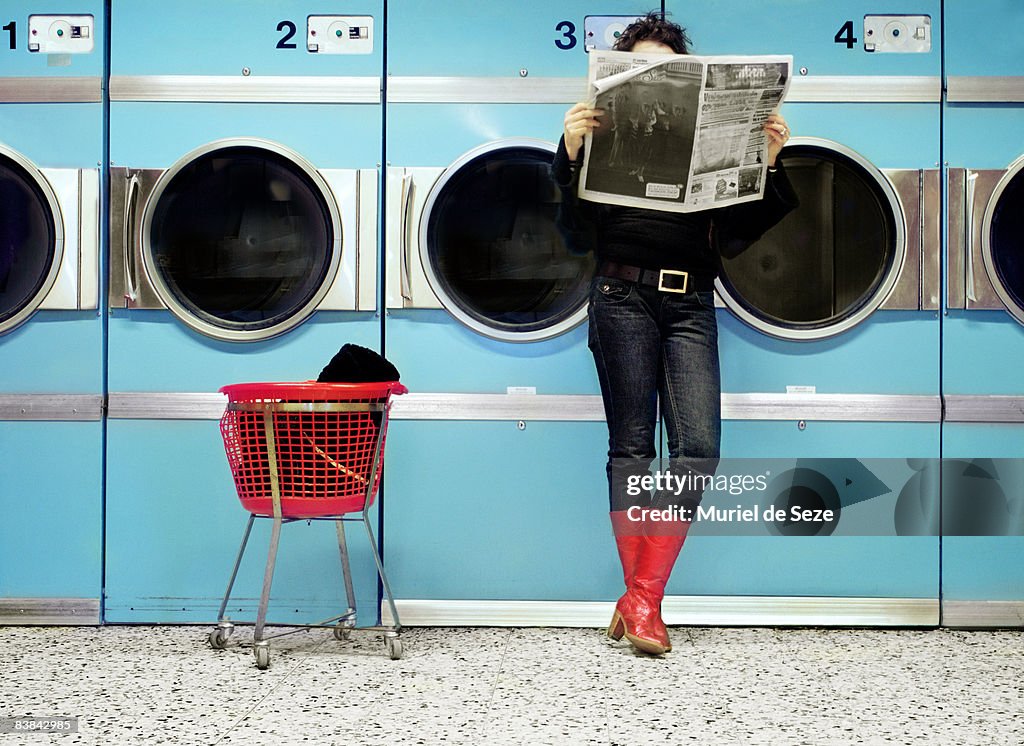 Woman reading at laundromat