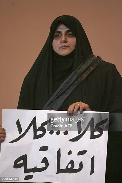 Maha al-Dori, a lawmaker loyal to anti-US Iraqi Shiite cleric Muqtada al-Sadr, holds banner that says "No, no to the agreement" after Iraqi...
