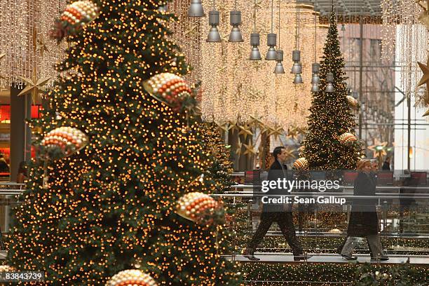 Shoppers walk among illuminated Christmas trees at the Arkaden shopping mall on November 27, 2008 in Berlin, Germany. German retailers are hoping for...