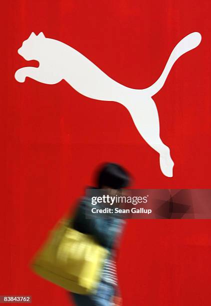 Woman talks on her mobile phone as she walks past a Puma store under construction during the Christmas season at the Arkaden shopping mall on...