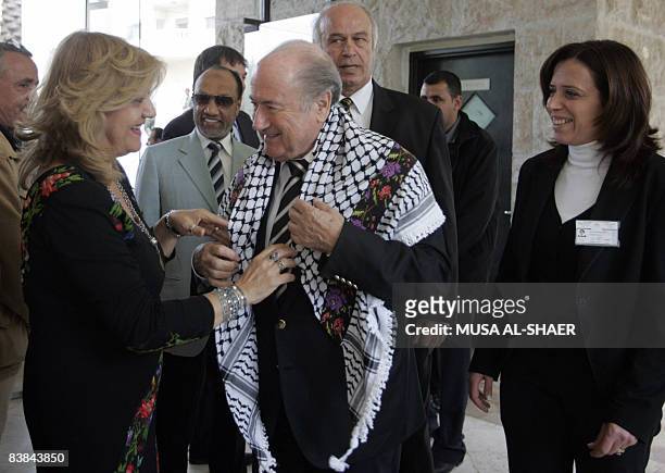 President Joseph Blatter receives a Keffiyeh, traditional Arab scarf, from Maha Saqa , head of the Palestinian heritage center in West Bank Biblical...