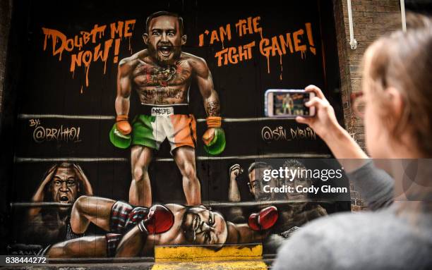 Dublin , Ireland - 24 August 2017; Whitney Baillie, from Syracuse, New York, takes a photo of a mural of Conor McGregor and Floyd Mayweather outside...