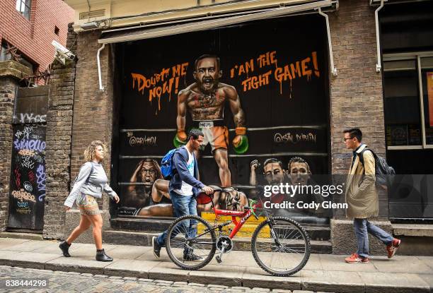 Dublin , Ireland - 24 August 2017; Pedestrians pass in front of a mural of Conor McGregor and Floyd Mayweather outside Sin Nightclub on Sycamore...