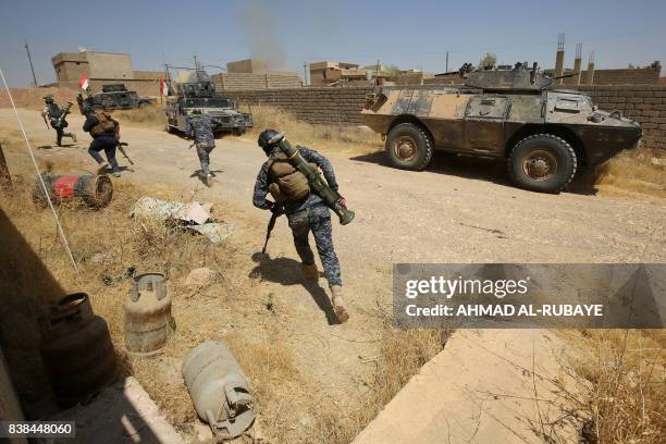 Iraqi forces, backed by the Hashed al-Shaabi , advance through Tal Afar's al-Wahda district during an operation to retake the city from the Islamic...