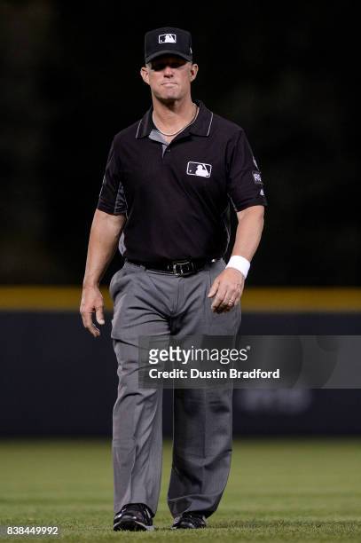 Umpire Jim Wolf looks on while wearing a white wristband in protest of verbal abuse from players during a game between the Colorado Rockies and the...