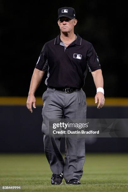 Umpire Jim Wolf looks on while wearing a white wristband in protest of verbal abuse from players during a game between the Colorado Rockies and the...