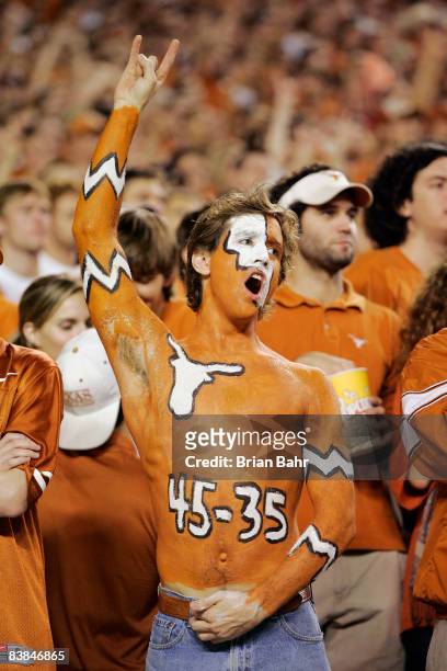 Texas Longhorn fan cheers on his team against the Texas A&M Aggies with a painted-on reminder of Texas score against Oklahoma earlier in the season...