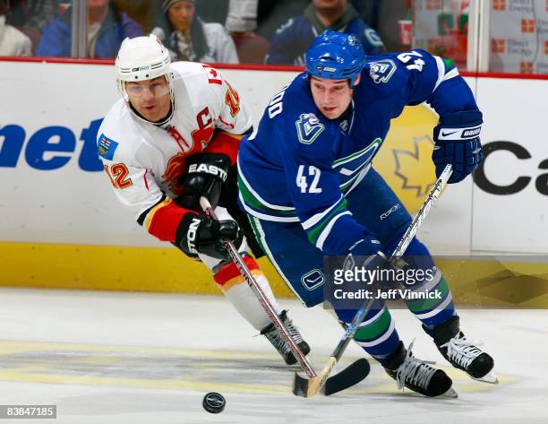Kyle Wellwood of the Vancouver Canucks beats Jarome Iginla of the Calgary Flames to the puck during their game against the Calgary Flames at General...