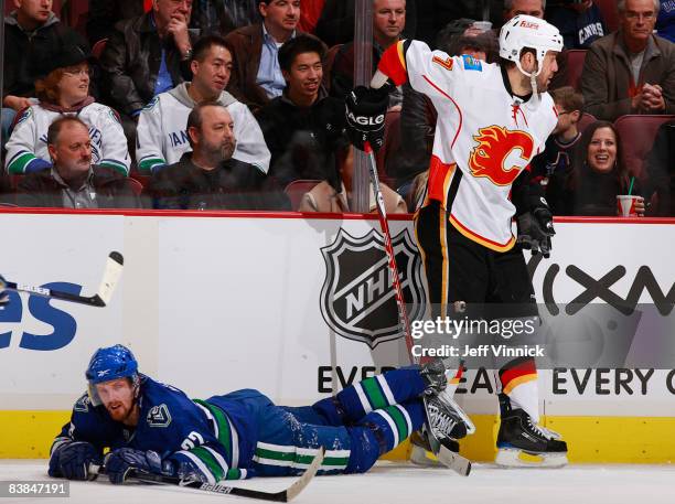 Henrik Sedin of the Vancouver Canucks gets tripped up by Todd Bertuzzi of the Calgary Flames at General Motors Place November 27, 2008 in Vancouver,...