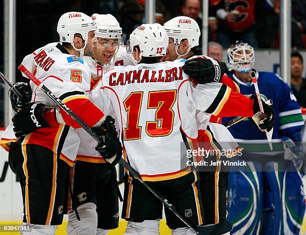 Jarome Iginla of the Calgary Flames celebrates with his teammates after a Calgary goal as Curtis Sanford of the Vancouver Canucks looks on dejected...