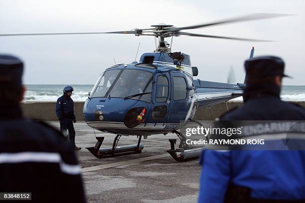 French gendarms stand around an helicopter of the French gendarmerie which is about to take off to scour the seas, on November 28 in Perpignan,...