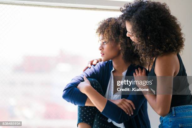 jonge vrouw haar vriend troosten - consoling stockfoto's en -beelden