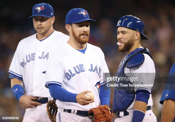 Danny Barnes of the Toronto Blue Jays exits the game as he is relieved in the seventh inning as Russell Martin looks on during MLB game action...