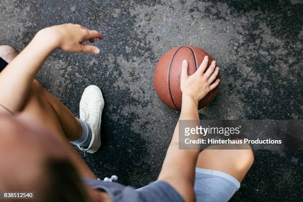 close up of young athlete kneeling with basketball - streetball stock-fotos und bilder