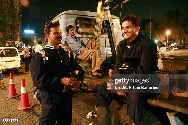 Police take a break outside the Chatrapati Shivaji Terminus on November 28, 2008 in Mumbai, India. Following terrorist attacks on three locations in...