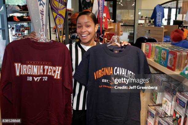 Woman holding shirts in the gift store at Virginia Sports Hall of Fame and Museum.