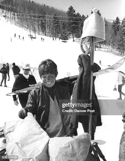 Jean Saubert, who tied for first in women's giant slalom Monday at Vail, packs be longings. Note Jean's unusual "hat rack" and big smile. Credit:...