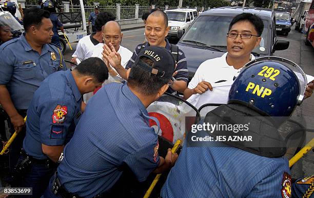 Anti-riot police block protesters trying to march to a military camp in Manila on November 29 where rebel soldier and senator Antonio Trillanes are...