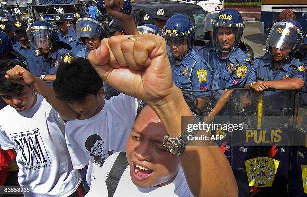 Anti-riot police block protesters trying to march to a military camp in Manila on November 29 where rebel soldiers and senator Antonio Trillanes are...