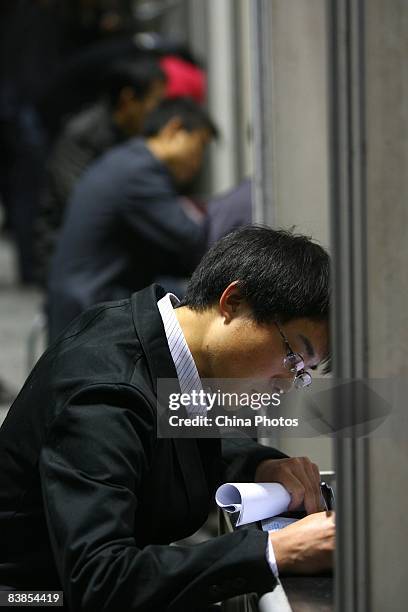 Graduating university student fills in an application form at a job fair on November 28, 2008 in Chongqing, China. The number of Chinese college...