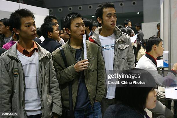 Couple of graduating university students read employment information at a job fair on November 28, 2008 in Chongqing, China. The number of Chinese...