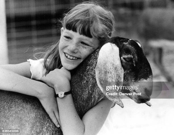 Amy Black Franktown, hugs An? gel, her yearling Nu? bian goat, after it won her first place at the Douglas County Fair. It is Amy’s first year as a...