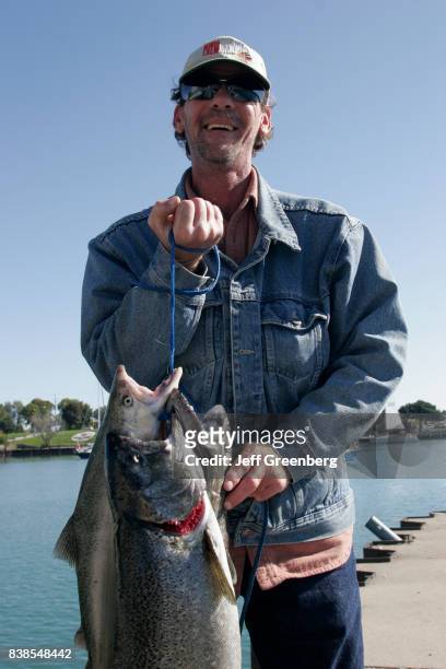Fisherman holding coho salmon at Kenosha Harbor.