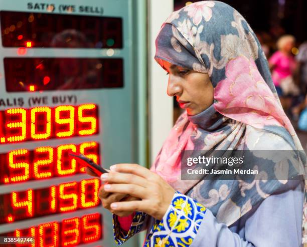 middle eastern woman using phone for checking currency - exchange rate bildbanksfoton och bilder